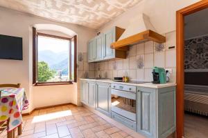 a kitchen with a stove and a window at Ledro Lake Suite "Pur" in Mezzolago