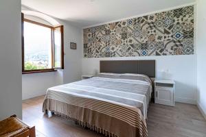 1 dormitorio con 1 cama y una pared con azulejos en Ledro Lake Suite "Pur", en Mezzolago