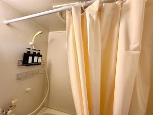 a bathroom with a shower with a shower curtain at 2名様におすすめ 山手駒込駅徒歩3分 Switch付き池袋新宿秋葉原上野浅草渋谷 in Tokyo