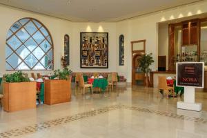 un restaurante con mesas y sillas y un cartel en Hilton Marsa Alam Nubian Resort en Abu Dabab