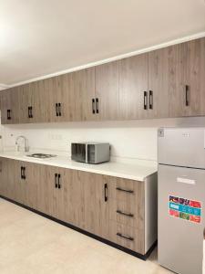 uma cozinha com armários de madeira e um frigorífico branco em مساكن الدار 15 em Abha