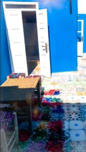 um quarto com uma mesa e uma porta azul em Dar merouan em Essaouira