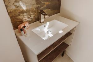 un lavabo blanc dans une salle de bain avec un miroir dans l'établissement Bel appartement 35 m 1er étage, à Évaux-les-Bains 27 autres photos