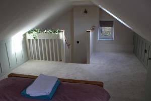 Camera mansardata con letto e scala. di Rose Cottage, Little Haven a Pembrokeshire