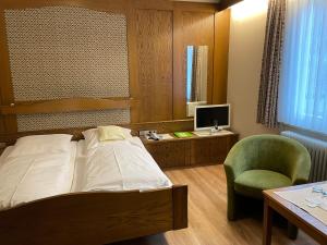 a bedroom with a bed and a desk and a chair at Hotel Waldlust in Baiersbronn