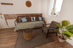 1 dormitorio con 1 cama, 1 silla y 1 reloj en Bel appartement 35 m 1er étage, en Évaux-les-Bains