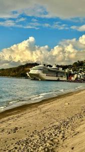 un crucero en el agua junto a una playa en Hygge's Inn, en Roseau