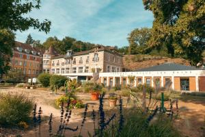 un bâtiment avec un jardin en face dans l'établissement Bel appartement 35 m 1er étage, à Évaux-les-Bains