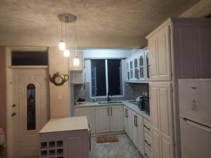a kitchen with white cabinets and a white refrigerator at Hygge's Inn in Roseau