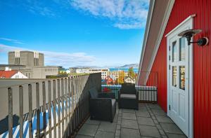 a balcony with two chairs and a red building at Canopy by Hilton Reykjavik City Centre in Reykjavík