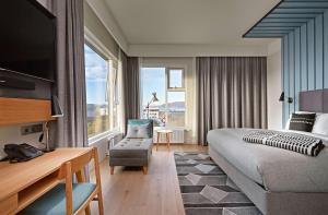 a hotel room with a bed and a chair at Canopy by Hilton Reykjavik City Centre in Reykjavík