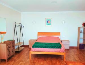 a bedroom with a bed and a wooden floor at Studio a Casa Valentina in Estreito da Calheta