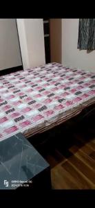 Mukadam home stay في تشيبلون: سرير ولحاف فوق طاولة