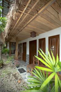 un porche de una casa con techo de madera en Tastura Homestay en Praya