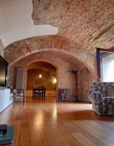 een woonkamer met een bakstenen muur en een bank bij "Il Pollaio" guests house in Panicale