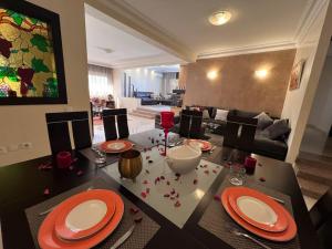 uma mesa de jantar com pratos vermelhos e copos em Rabat-Agdal, Modern & Spacious Apartment at StayInMoroccoVibes em Rabat