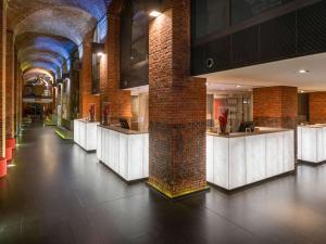 a lobby with a row of white counter tops at Mövenpick Hotel Hamburg in Hamburg