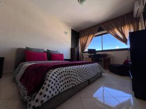 um quarto com uma cama grande e almofadas vermelhas em Rabat-Agdal, Modern & Spacious Apartment at StayInMoroccoVibes em Rabat