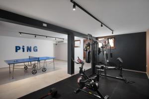 un gimnasio con mesa de ping pong y equipo de ejercicios en Malibu Royal, en Vir