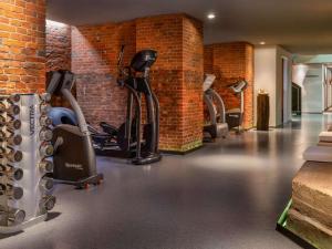 einen Fitnessraum mit Kardiogeräten in einer Ziegelwand in der Unterkunft Mövenpick Hotel Hamburg in Hamburg