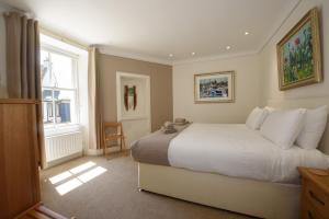 a bedroom with a large white bed and a window at House on the Harbour Pittenweem in Pittenweem