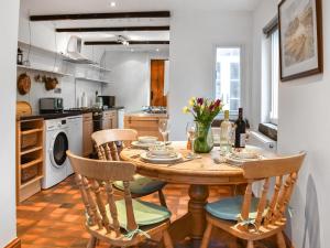 a kitchen with a wooden table with chairs and a dining room at Beech Cottage in Carnforth