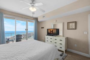 a bedroom with a bed and a television and a balcony at Ariel Dunes II 2203 in Destin