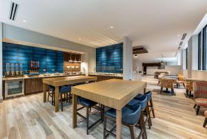 una cocina con mesas de madera y sillas azules en Hilton Garden Inn- Chicago Central Loop, en Chicago