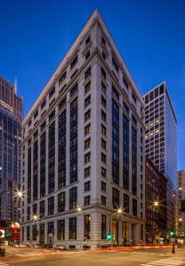 芝加哥Canopy By Hilton Chicago Central Loop的夜行的街道上一座白色的大建筑