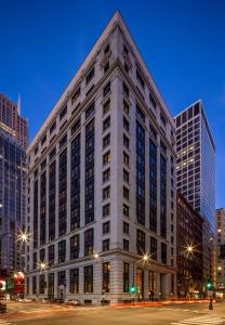 a large white building on a city street at night at Canopy By Hilton Chicago Central Loop in Chicago