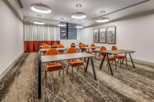 a conference room with tables and orange chairs at Hilton Garden Inn- Chicago Central Loop in Chicago