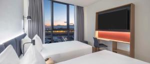 a hotel room with two beds and a flat screen tv at Hampton by Hilton Antalya Airport in Antalya