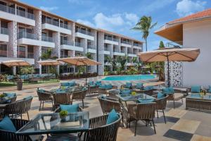 una vista exterior del complejo con mesas y sillas y una piscina en Hyatt Place Goa Candolim, en Candolim