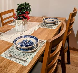una mesa de madera con platos azules y blancos. en Dom na skarpie z widokiem na jezioro, z kominkiem i garażem, en Stary Dzierzgoń