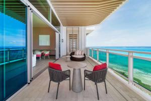 a balcony with a table and chairs and the ocean at Wyndham Grand Barbados Sam Lords Castle All Inclusive Resort in Saint Philip