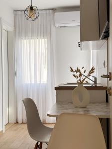 una cocina con mesa y sillas y un jarrón de flores en Danin apartmani, en Bar