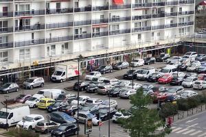 a parking lot with cars parked in front of a building at Cozy Relaxing View Apartment ! Walk to Amenities! in Melun