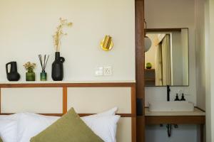 a bedroom with a bed with a mirror and a sink at The Birdhouse Uluwatu 2BR Treetop Private Home with Deep Plunge Pool in Uluwatu