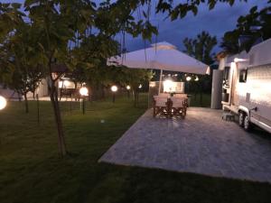 - une table et des chaises dans la cour la nuit dans l'établissement Delightful RV Camper In a Peaceful Area near Sea., à Skála Foúrkas