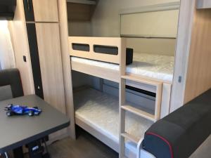 Cette petite chambre comprend des lits superposés et un bureau. dans l'établissement Delightful RV Camper In a Peaceful Area near Sea., à Skála Foúrkas