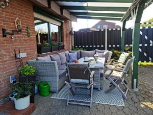 a patio with a couch and a table and chairs at Pension Bütterich in Husum