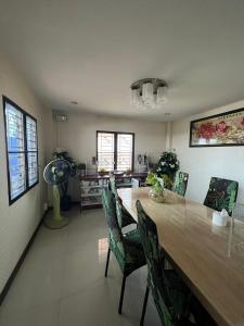 a dining room with a large wooden table and chairs at พนาสนธิ์แหลมหินรีสอร์ท in Ban Laem Hin