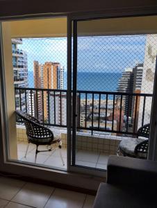 a balcony with two chairs and a view of the ocean at Villa damasco in Fortaleza