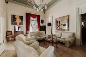 a living room with white furniture and a chandelier at Dimora Emilia by Vivimy in Alessano