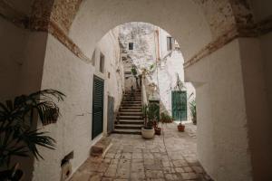an alley with stairs and potted plants in an archway at Dimora Emilia by Vivimy in Alessano
