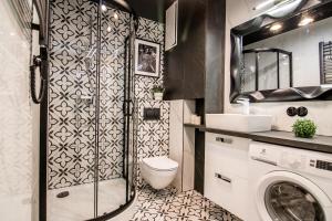 a bathroom with a toilet and a washing machine at Polpo Apartments B&B in Łódź +118 photos