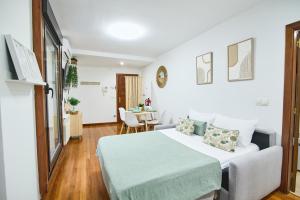 Un dormitorio blanco con una cama y una mesa. en Serranos 24 Apartamento Rector Cobos, en Salamanca