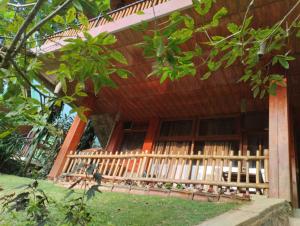 - un bâtiment en bois avec une terrasse couverte en face dans l'établissement Ella Wood Cabin, à Ella