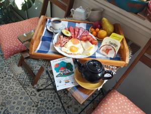 a breakfast tray with eggs and fruit on a table at La Casa de La Abuela Rosy in Málaga