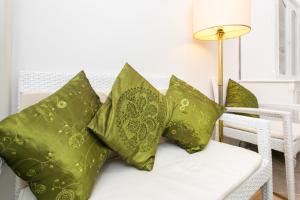a white couch with four green pillows on it at Apartments Adriana Flora in Dubrovnik